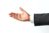 Businessman's open hand extended in greeting gesture against white background, formal suit sleeve visible, representing professional communication.