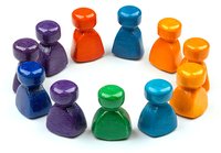 Colorful wooden game pieces arranged in circle formation on white background, showing diversity and teamwork concept. Suitable for business presentations and education materials.