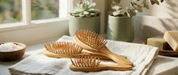 Wooden hair brushes with natural bristles on white towel near window with succulents in modern bathroom spa setting for wellness and self-care routine.