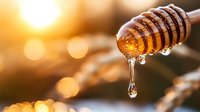 Golden honey dripping from wooden dipper against warm sunset backdrop with bokeh effect. Organic sweetener for culinary and wellness content.