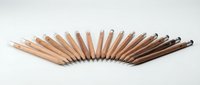 Row of wooden colored pencils arranged in gradient from light to dark brown tones on white background for art and design projects.