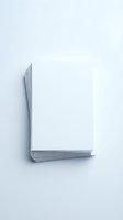 Stack of blank white paper sheets arranged in L-shape on light gray background. Minimalist office supplies concept for business and education materials.