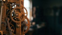 Vintage mechanical clock mechanism with brass gears and springs showcasing intricate clockwork engineering and timekeeping craftsmanship details.