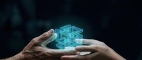 Two hands holding a glowing blue geometric holographic cube structure against dark background, representing technology, innovation, digital transformation, and future business solutions.