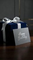 Elegant navy blue velvet gift box with silver ribbon bow and gray Happy Birthday card on dark wooden surface, luxury celebration concept.