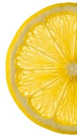 Fresh lemon slice isolated on white background with visible juice droplets and detailed segment texture, suitable for food and beverage design projects.