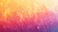 Water drops on glass with vibrant orange, pink and purple gradient background creating dreamy bokeh effect and abstract texture for creative designs.