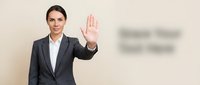 Professional businesswoman in gray suit making stop gesture with raised palm against neutral background for corporate communication concepts.