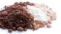 Cocoa powder and flour piles isolated on white background for baking ingredients and culinary preparations.