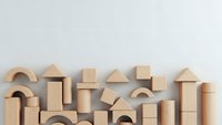 Natural wooden building blocks arranged on white background showcasing various geometric shapes for educational play and creative construction activities.