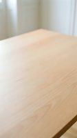 Light wood table surface with natural grain texture and soft focus background, suitable for product placement, lifestyle photography, and interior design projects.