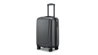 Modern gray hardshell suitcase with four wheels and telescopic handle isolated on white background for travel and vacation concepts.