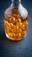 Glass bottle filled with golden amber liquid and spherical capsules, suitable for pharmaceutical, supplement, wellness, and medical packaging design projects.