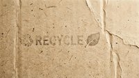 Recycled cardboard texture with eco-friendly symbol and leaf icon. Sustainable packaging material background for environmental design projects.