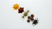 Colorful spice collection with turmeric, paprika, herbs and star anise arranged on white background for culinary cooking and seasoning recipes.