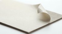 Elegant cream textured paper with curved fold creating dimensional shadow on white background for premium stationery and design projects.