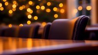 Empty luxury restaurant interior with leather chairs and wooden table at night, warm bokeh lights creating romantic ambiance for fine dining experience.