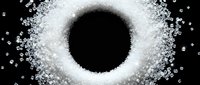 White sugar crystals scattered in circular pattern around black empty center on dark background, suitable for food, confectionery, and culinary design projects.