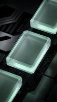 Futuristic glowing green glass cubes floating above dark metallic circuit board surface with electronic patterns for technology and innovation concepts.