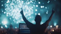 Male silhouette with raised arms against blurred bokeh lights and fireworks at outdoor music festival, celebrating with crowd in nighttime atmosphere.