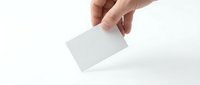 Hand holding blank white business card on isolated background, ready for branding and corporate identity design mockup.