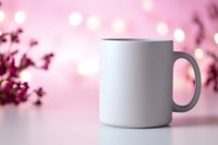 White ceramic coffee mug mockup on pink bokeh background with blurred flowers. Clean minimal product photography for branding and design presentation.