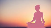 Woman silhouette meditating in lotus pose during sunset with peaceful gradient sky background for wellness and mindfulness concepts.