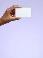 Male hand with medium-dark skin tone holding blank white card against lavender background. Ideal for business card mockups, branding presentations, and corporate identity designs.