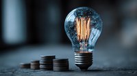 Glowing vintage light bulb with warm filament next to stacked coins representing energy costs, electricity bills, and financial planning concepts.