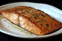 Grilled salmon fillet with herbs on white plate, perfectly cooked seafood dish for healthy dining and gourmet cooking recipes.