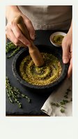 Hands grinding fresh herbs with wooden pestle in stone mortar, natural cooking ingredients preparation for culinary recipes and healthy meals.