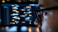 Professional businessman analyzing financial data on computer screen with city lights bokeh background at night office.
