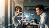 Two diverse business professionals analyzing holographic data visualization and charts in modern office environment for strategic planning and decision making.