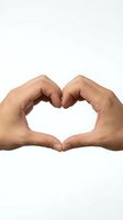 Two hands forming heart shape gesture on white background isolated for love and care concepts.
