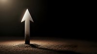 Glowing upward arrow emerging from textured ground surface against dark background symbolizing growth progress and success in business concepts.