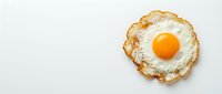 Fried egg with golden crispy edges and bright orange yolk on white background, isolated breakfast food ready for culinary design projects.