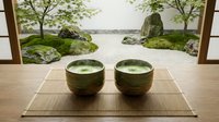 Two ceramic matcha tea bowls on a bamboo mat with a serene zen garden view, rocks and moss trees in background.