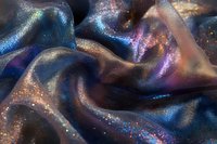 Shimmering dark fabric with holographic glitter effect creates cosmic waves and folds, featuring deep blues and purples with scattered iridescent sparkles.