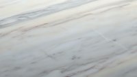 Elegant white marble surface with subtle gray and pink veining patterns for luxury interior design and architectural applications.