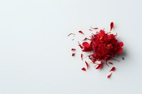Scattered bright red flower petals and fragments creating dynamic composition on white background, isolated with dramatic lighting and soft shadows.