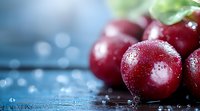 Fresh ripe plums with water drops on dark blue wooden surface, macro shot with selective focus and natural lighting, for food packaging design.