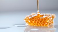 Golden honey dripping from spoon onto fresh honeycomb piece with hexagonal pattern structure, close-up view showing natural sweetness and organic texture.