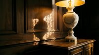 Silhouette of adult male figure standing in dimly lit wooden interior with ornate table lamp casting warm glow, classic home decor and interior design concept.