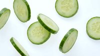Fresh cucumber slices floating on white background, perfect for healthy eating, diet, nutrition and culinary design projects.