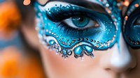 Close-up of woman with elaborate blue carnival mask featuring intricate beadwork and rhinestones around striking blue eyes for masquerade celebration.