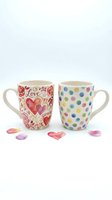 Pair of ceramic mugs with love and polka dot designs, isolated on white background, ready for product photography, gift sets, and e-commerce use.