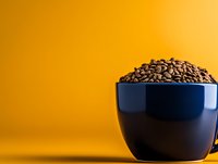 Roasted coffee beans overflowing from dark blue ceramic bowl against warm golden yellow background, suitable for cafe, beverage, and food industry marketing materials.