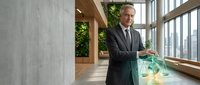 Middle-aged Caucasian businessman in suit holding scales of justice in modern office with large windows and plants, representing legal consulting services.
