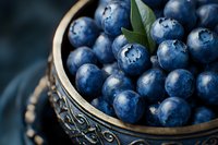 Fresh ripe blueberries in ornate wooden bowl with green leaves, healthy organic superfood berries for cooking, baking and nutrition concepts.