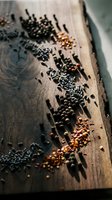 Assorted spices and seeds scattered on rustic wooden cutting board creating aromatic culinary ingredient display for cooking and seasoning recipes.